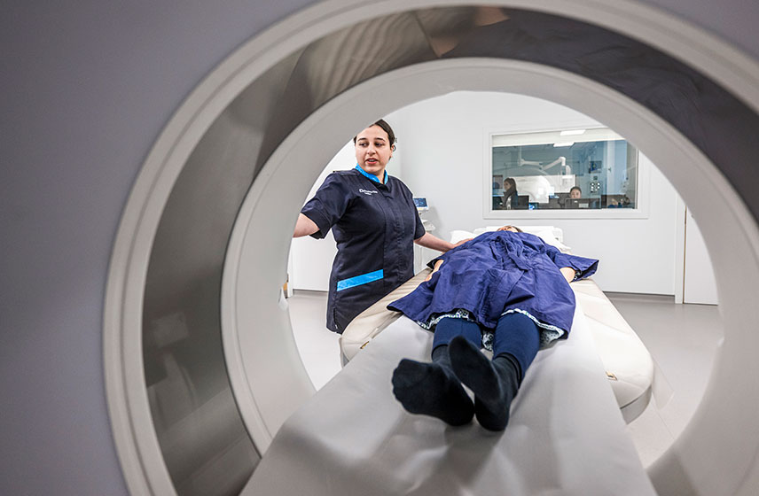 Medical staff performing a CT scan on a patient.