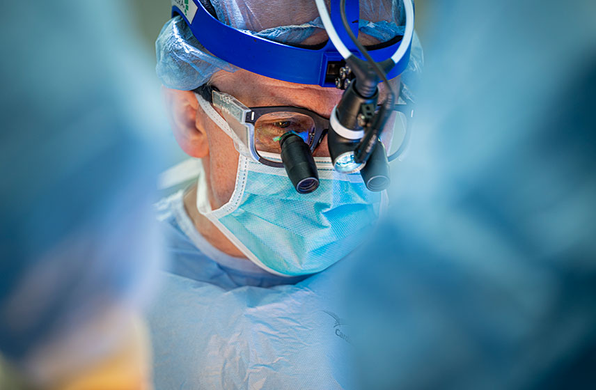 Surgeon in surgical gear performing operation.