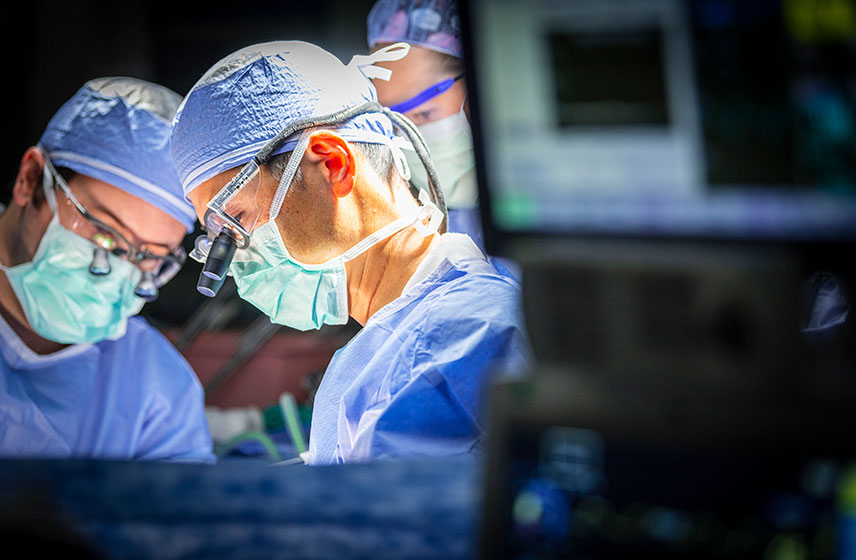 Two consultants operating on a patient