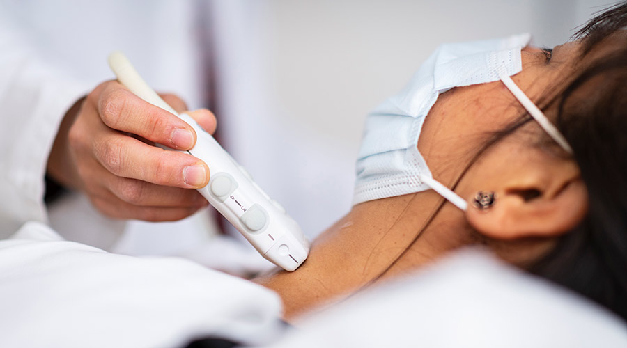 Cleveland Clinic caregiver performing an ultrasound on a patients neck.