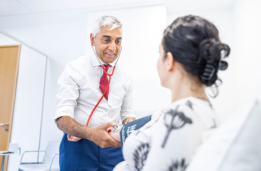 Caregiver checking the blood pressure of a patient.